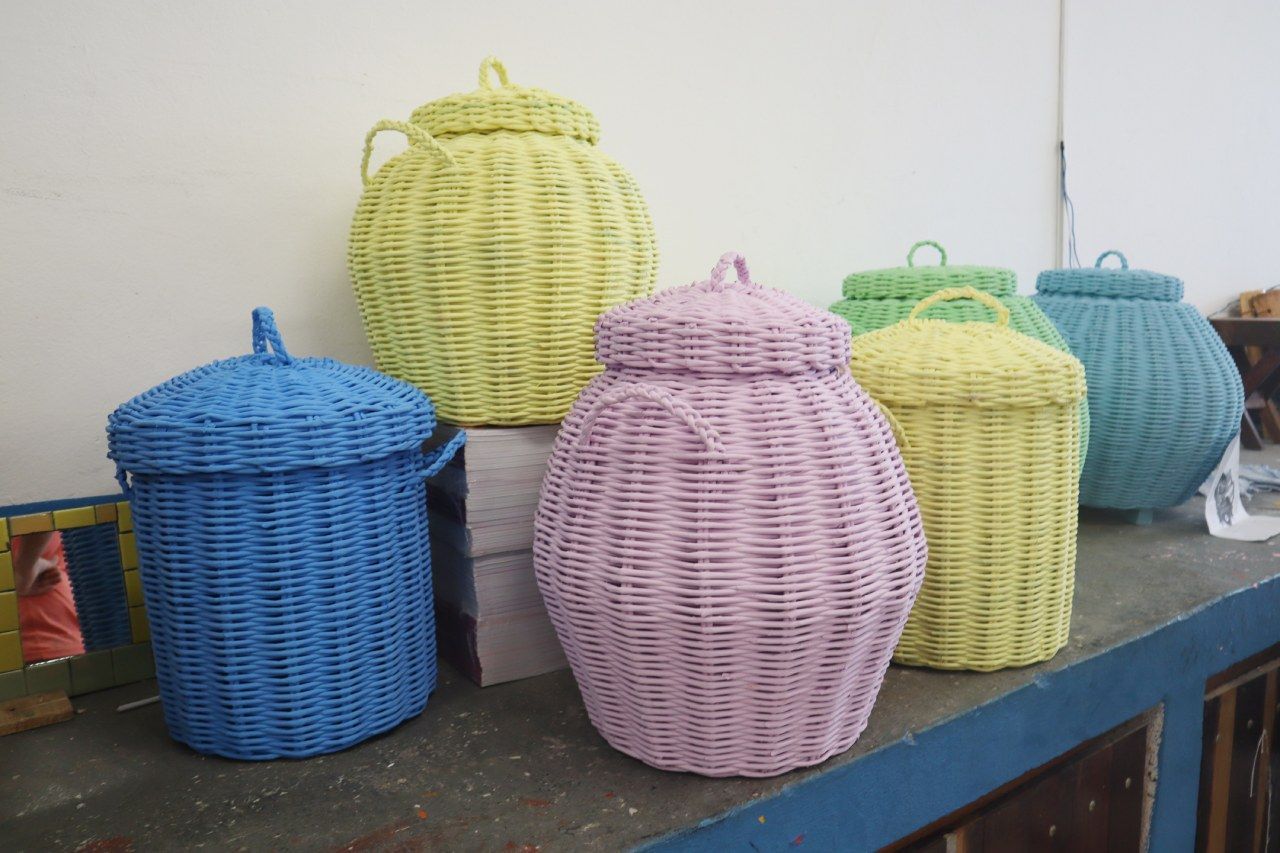 Um monte de cestos de vime coloridos estão sobre uma mesa.