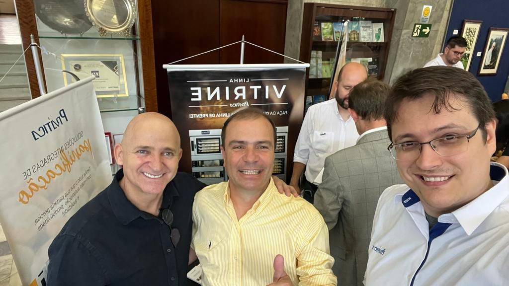 Um grupo de homens está posando para uma foto em uma sala.