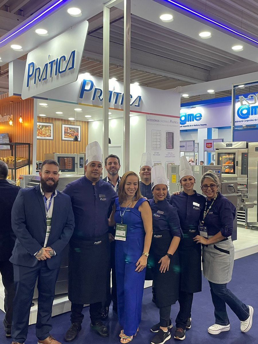 Um grupo de pessoas está posando para uma foto em uma convenção.