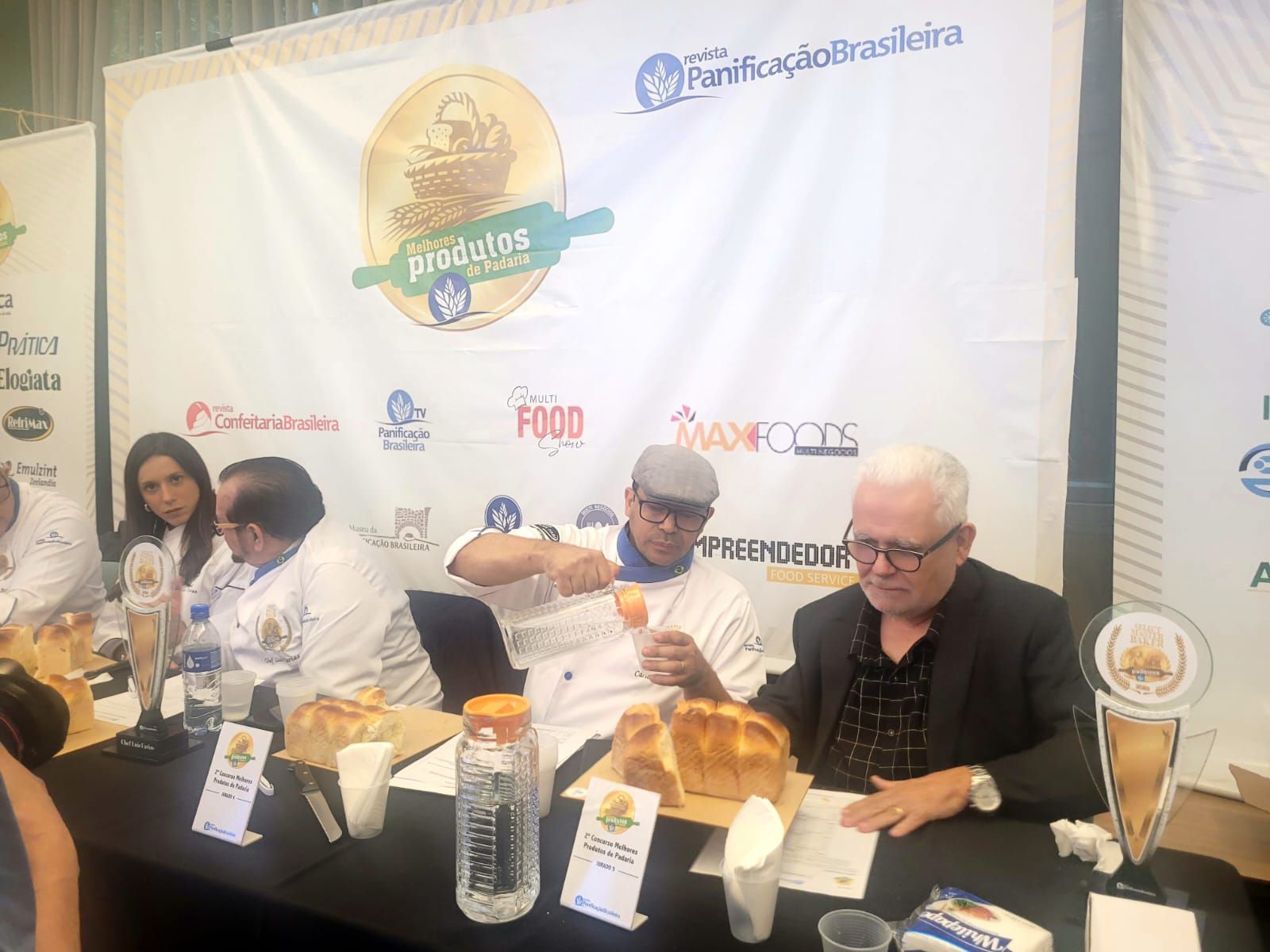 Um grupo de pessoas está sentado à mesa comendo.