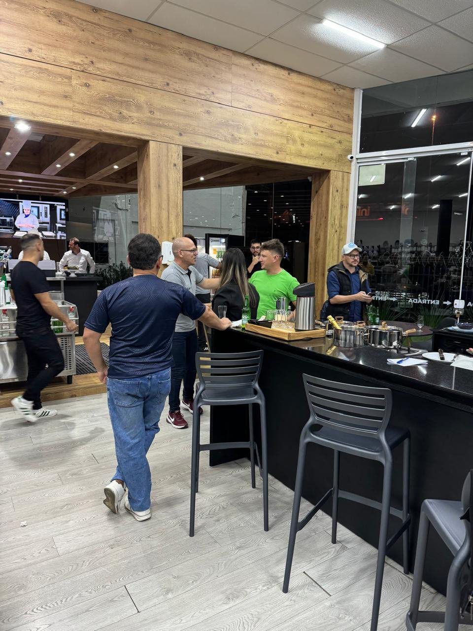 Um grupo de pessoas está em volta de um bar em um restaurante.