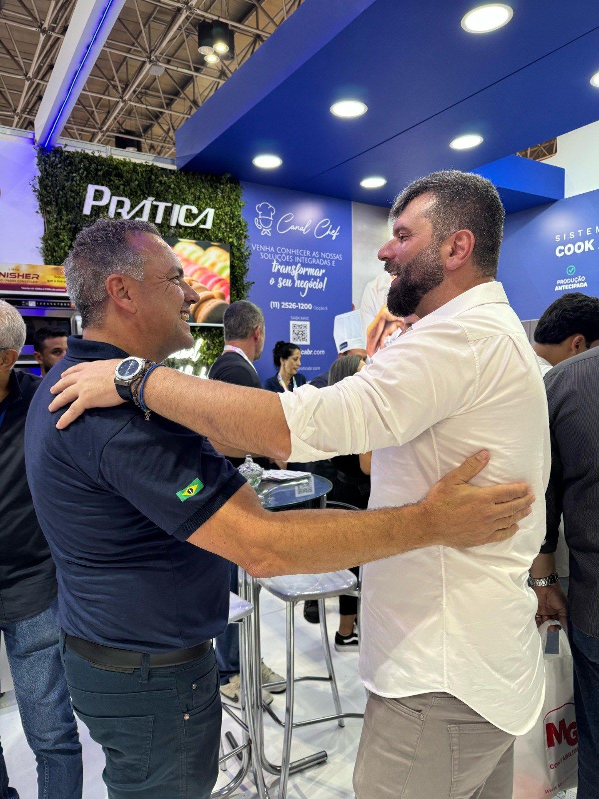 Dois homens estão se abraçando em uma convenção.