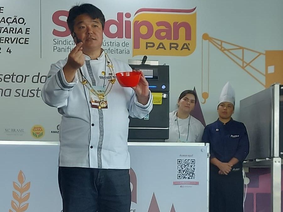 Um homem está em frente a uma placa que diz dipan para