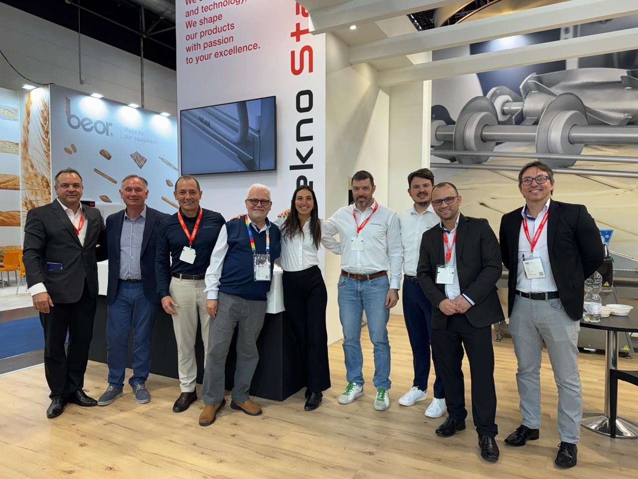 Um grupo de pessoas está posando para uma foto em uma convenção.