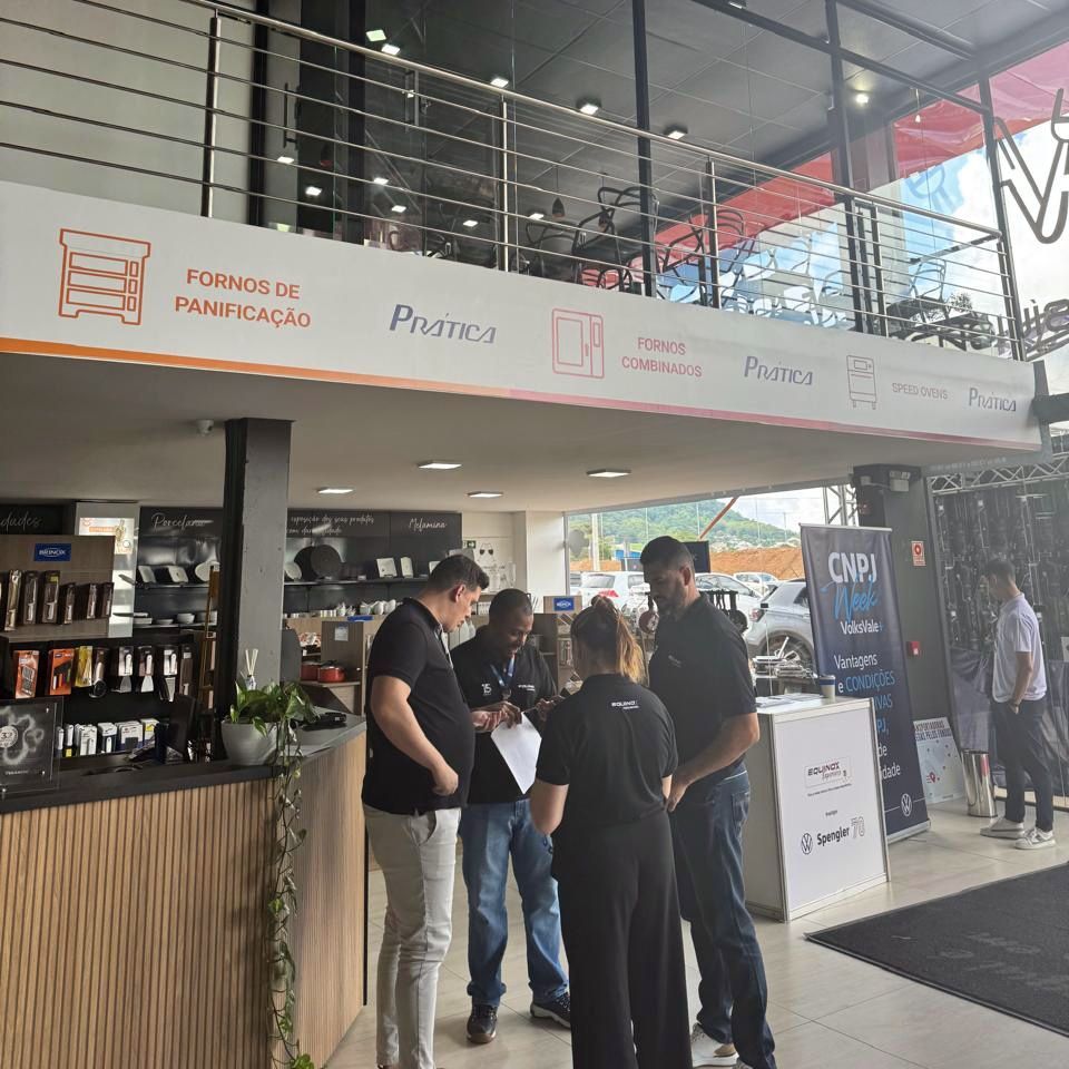 A group of people standing under a sign that says forno de panificação