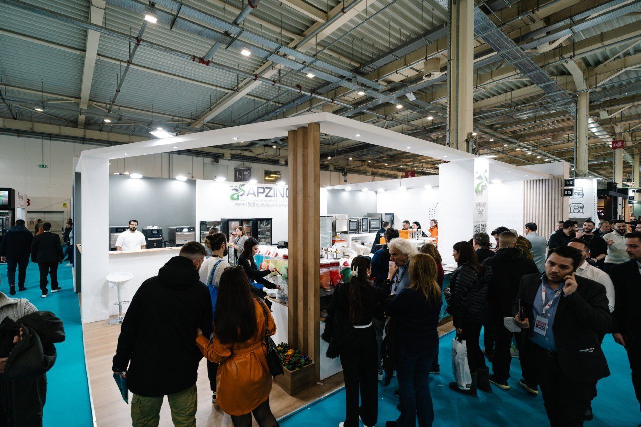 Um grupo de pessoas está em volta de um estande em uma convenção.