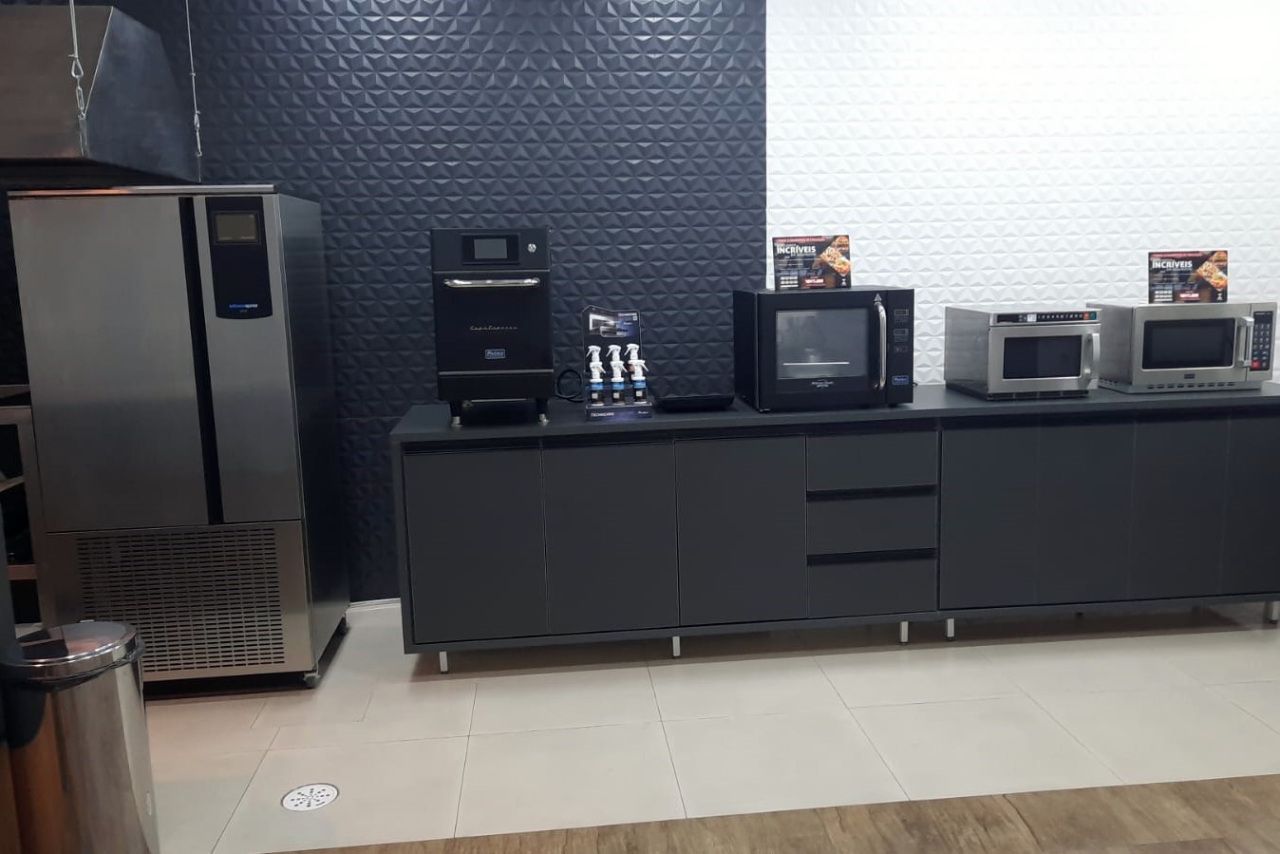 Uma cozinha com geladeira, micro-ondas e fogão.