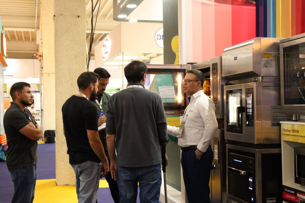 Um grupo de homens está em uma sala conversando entre si.