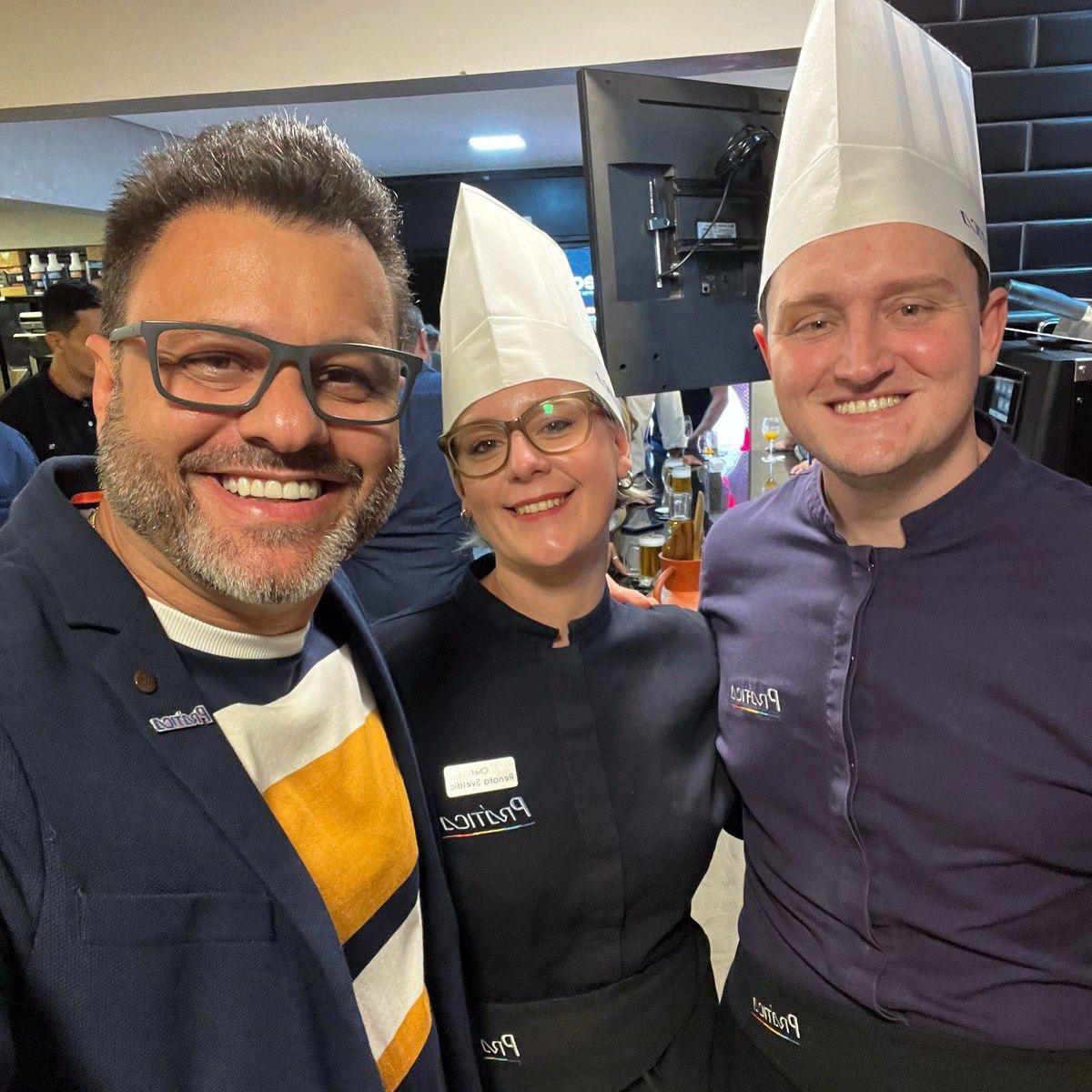 Três pessoas usando chapéus de chef posando para uma foto
