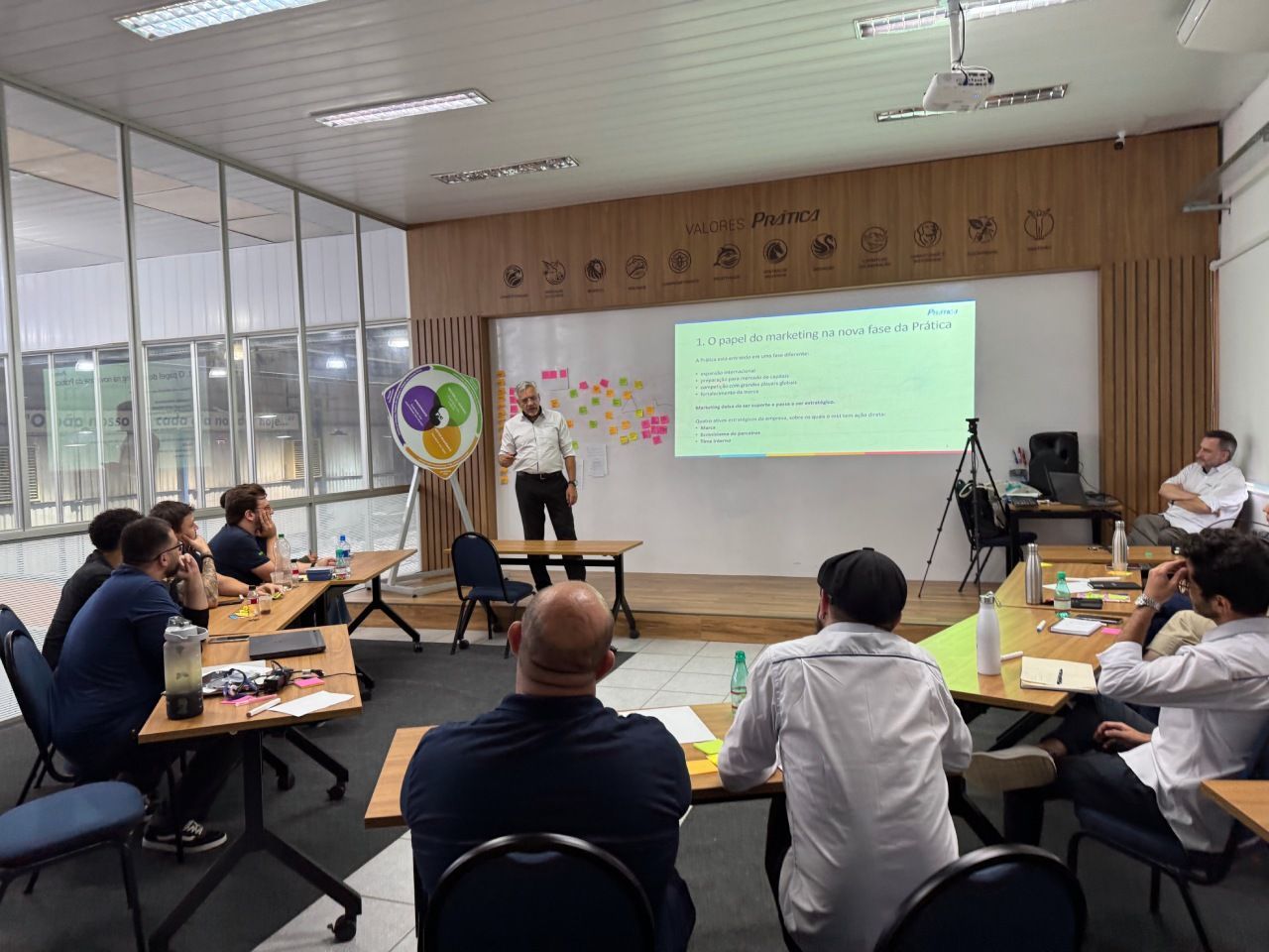 Um apresentador está de pé diante de um grupo em uma sala