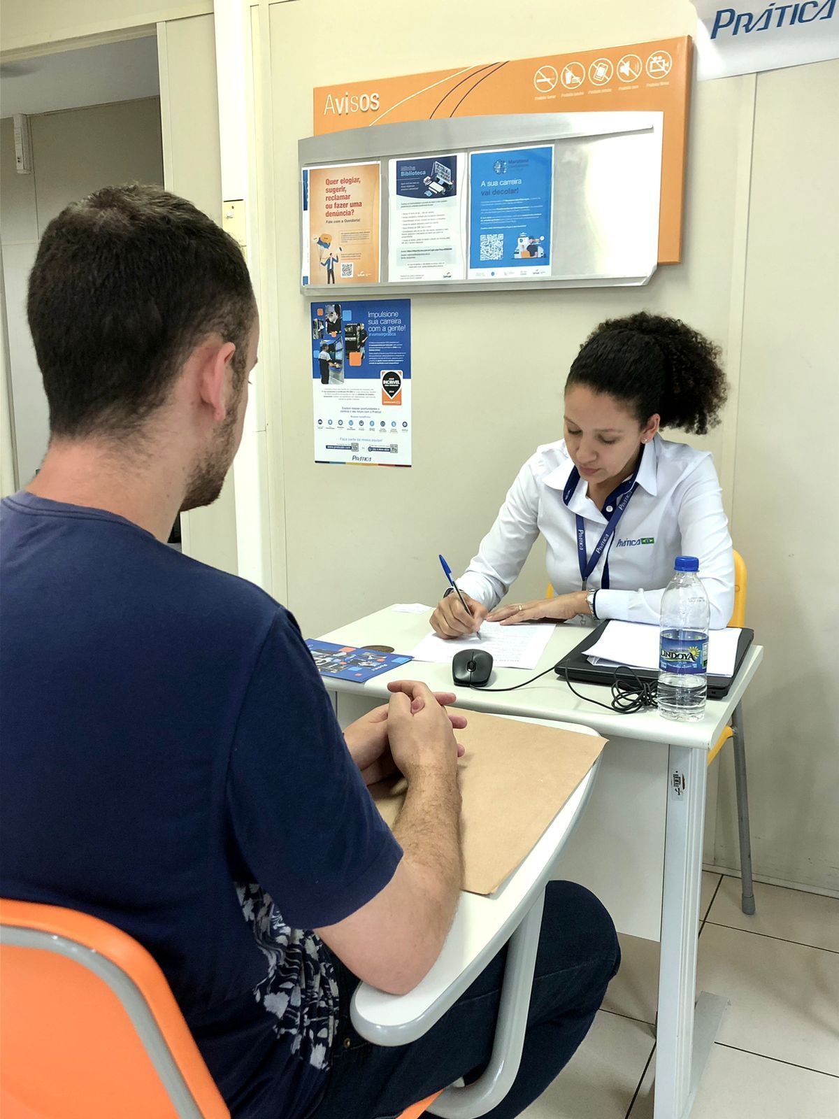 Um homem está sentado à mesa conversando com uma mulher.