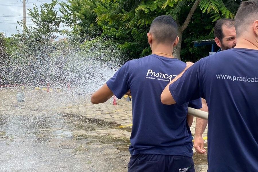Um grupo de homens está borrifando água de uma mangueira.