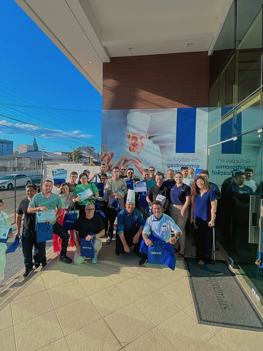 Um grupo de pessoas está posando para uma foto em frente a um prédio.