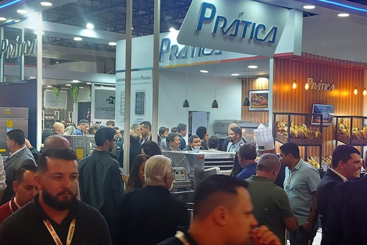 Um grupo de pessoas está em frente a uma placa que diz prática