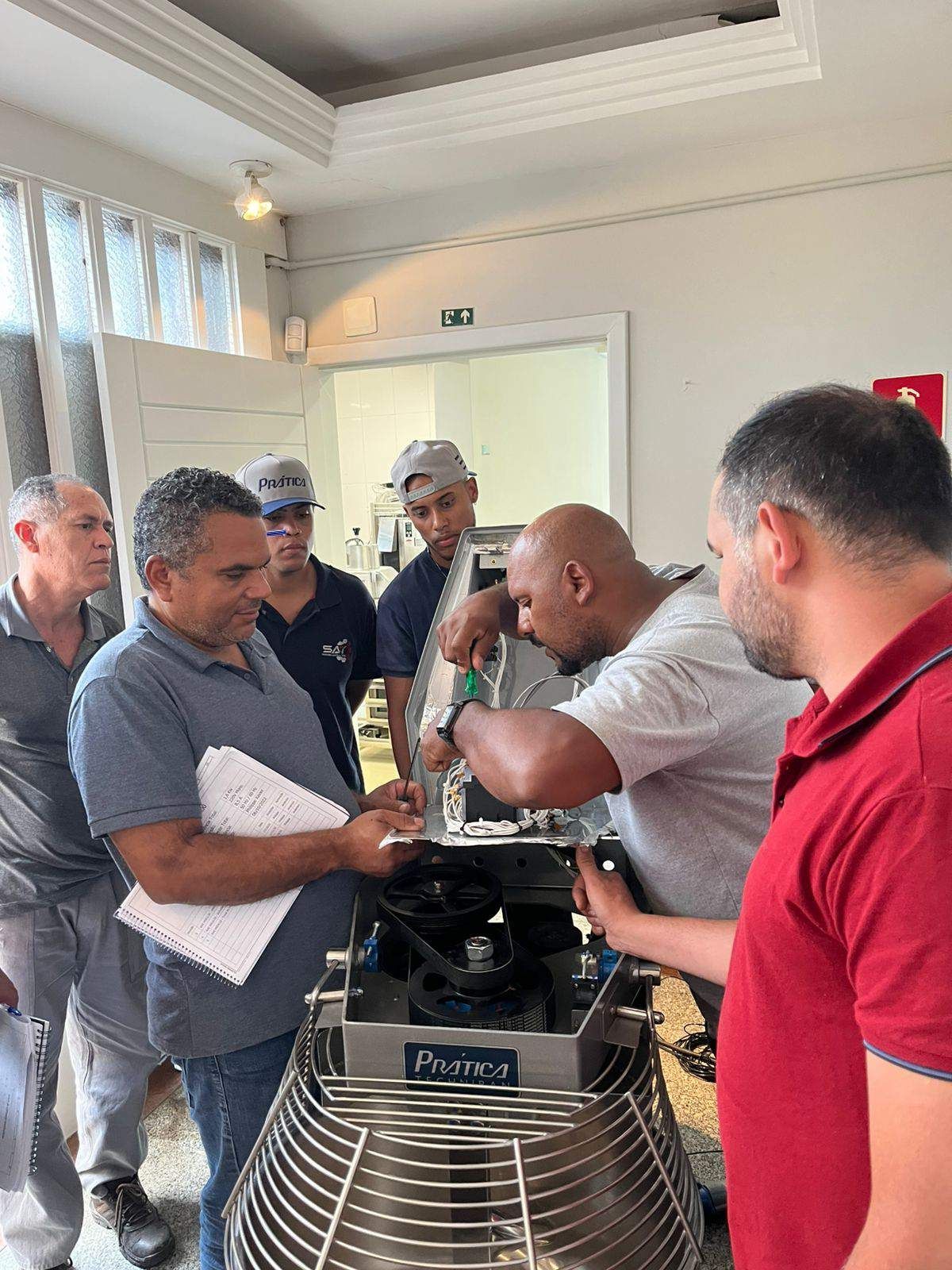 Um grupo de homens está trabalhando em uma máquina em uma sala.