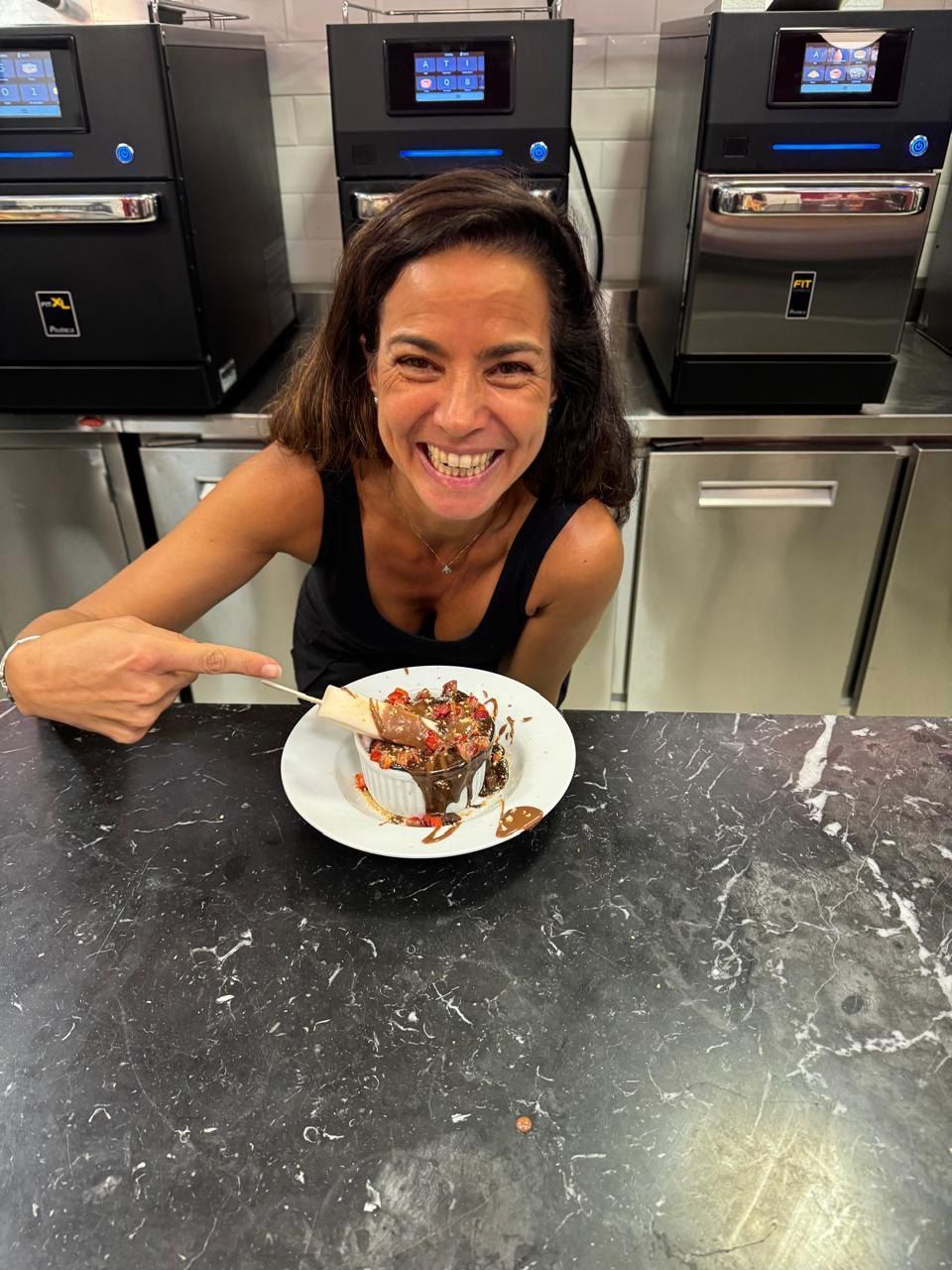 Uma mulher está apontando para um prato de comida em um balcão.