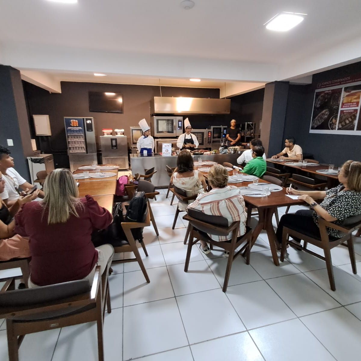 Um grupo de pessoas está sentado em mesas em um restaurante.