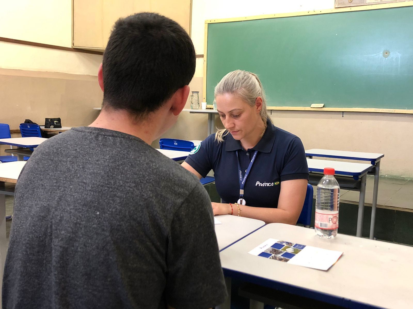 Uma mulher está conversando com um homem em uma sala de aula