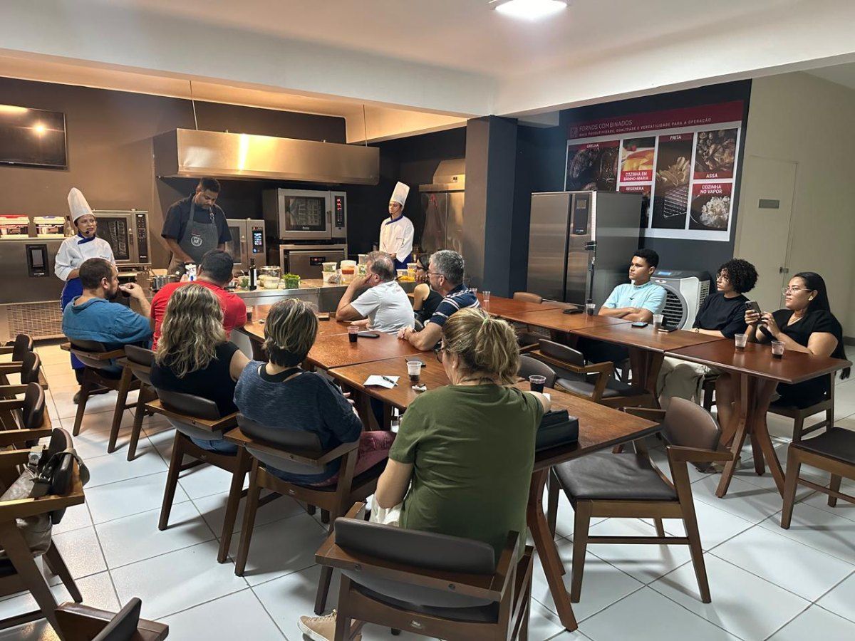 Um grupo de pessoas está sentado em mesas em um restaurante.