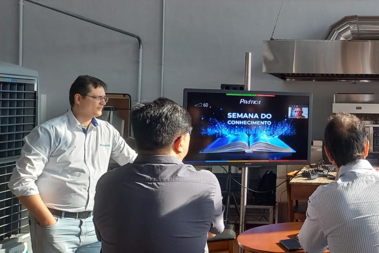 Um grupo de homens está sentado em frente a uma televisão.