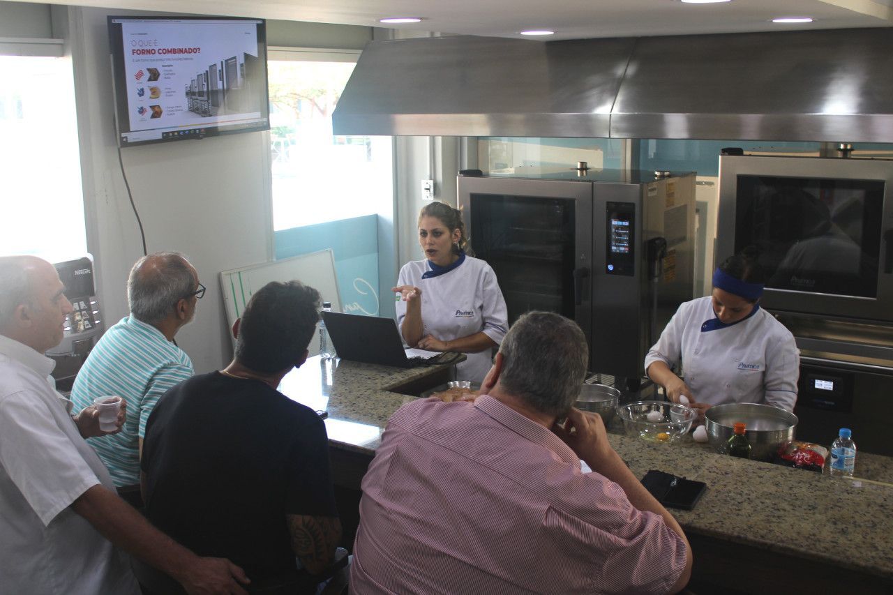 Um grupo de pessoas está sentado em um balcão na cozinha.