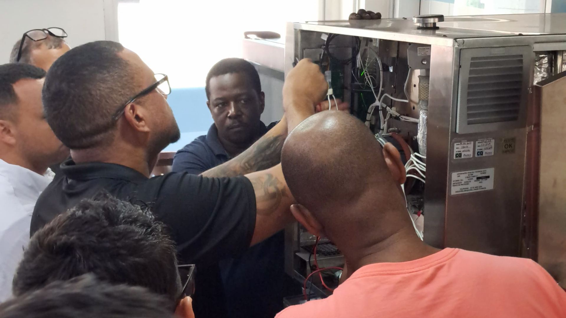 Um grupo de homens está trabalhando em uma máquina.