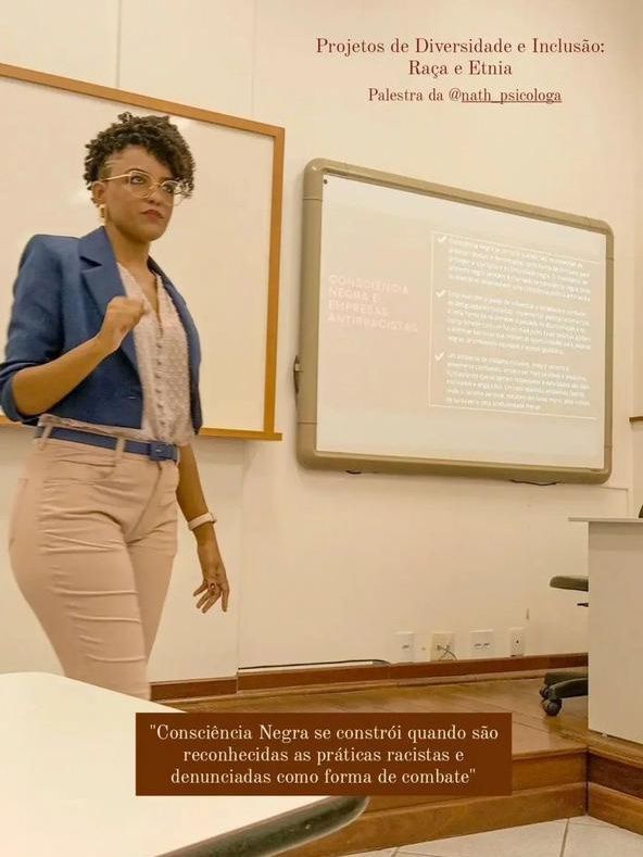 Uma mulher está parada em frente a um quadro branco em uma sala de aula.