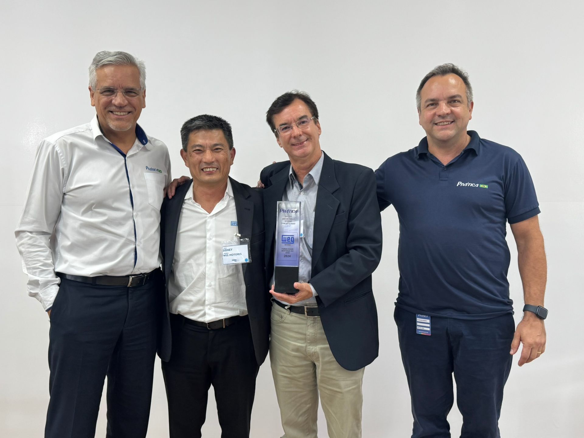 Um grupo de homens está posando para uma foto enquanto um deles segura um troféu.