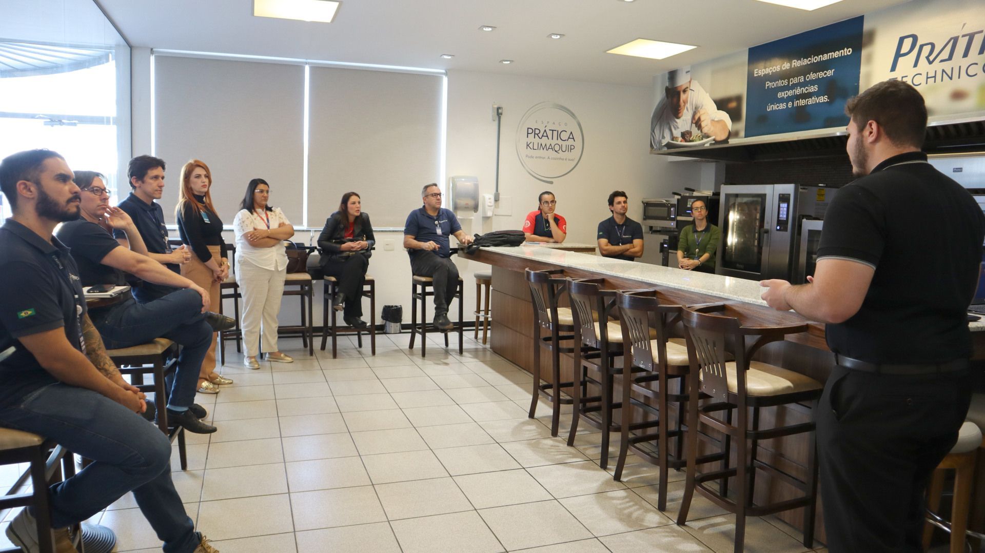 Um homem está fazendo uma apresentação para um grupo de pessoas em um restaurante.
