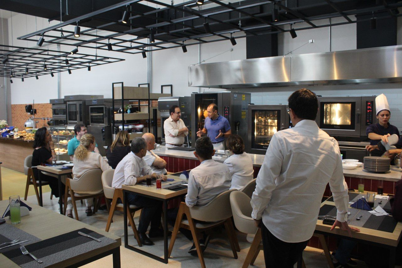 Um grupo de pessoas está sentado em mesas em um restaurante.
