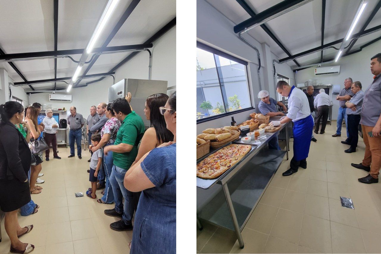 Um grupo de pessoas está em pé ao redor de uma mesa com comida.