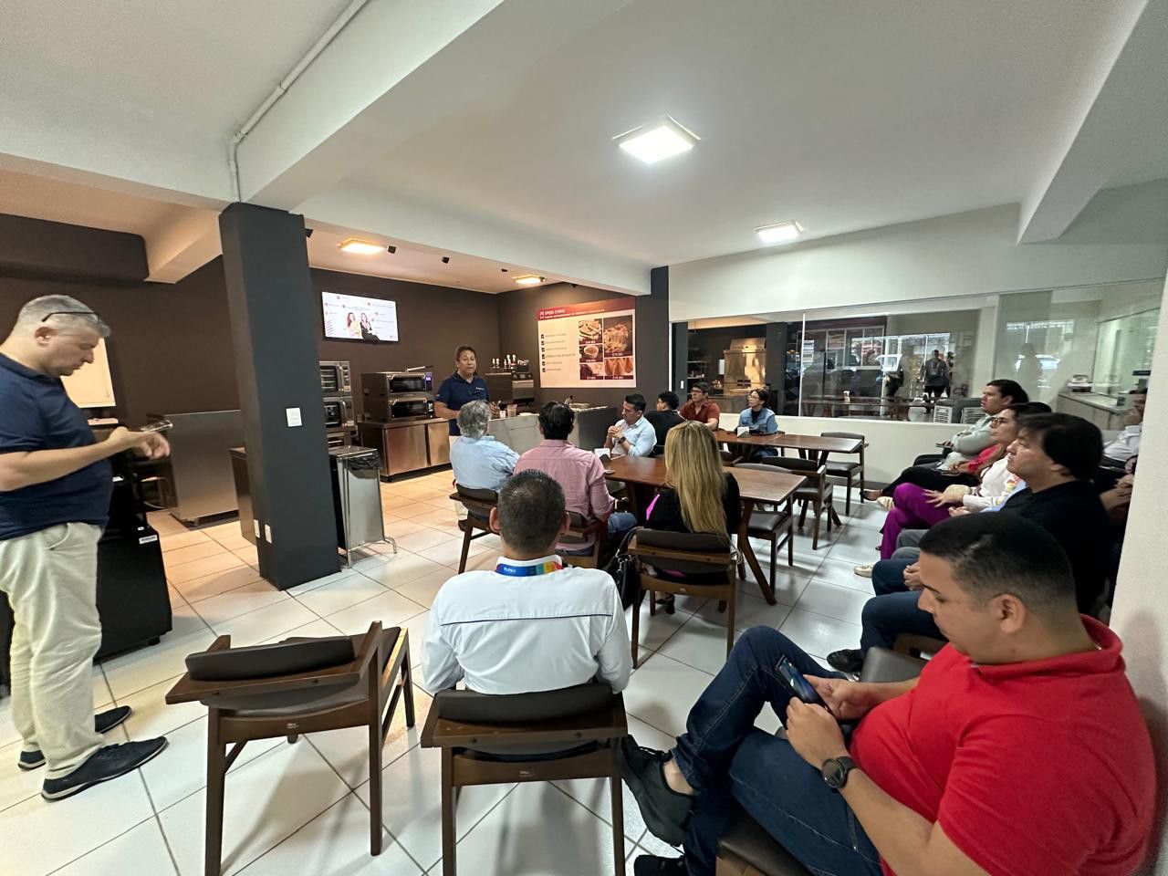 Um grupo de pessoas está sentado em cadeiras em uma sala.