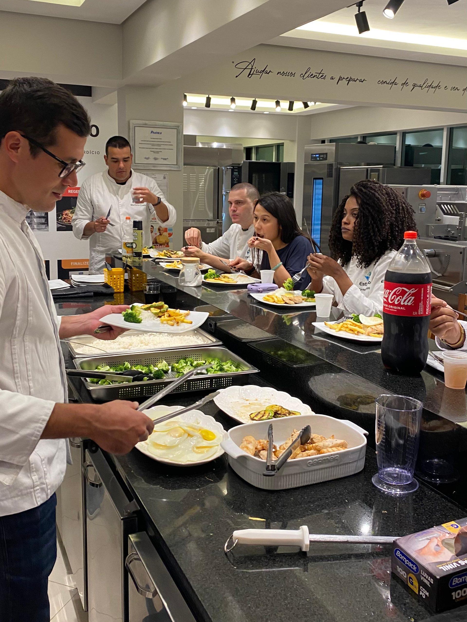 Um grupo de pessoas está sentado à mesa comendo.