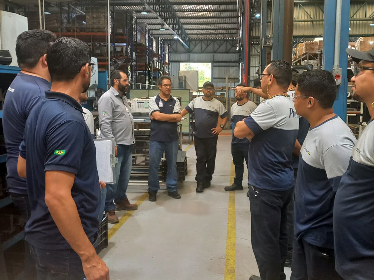 Um grupo de homens está em um armazém conversando entre si.