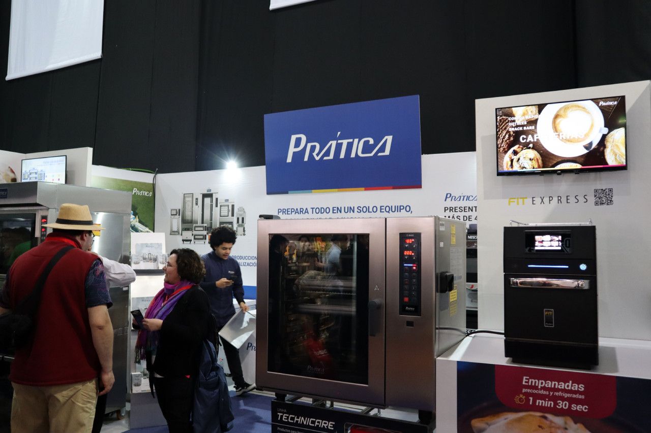 Um grupo de pessoas está em pé na frente de uma placa de prática