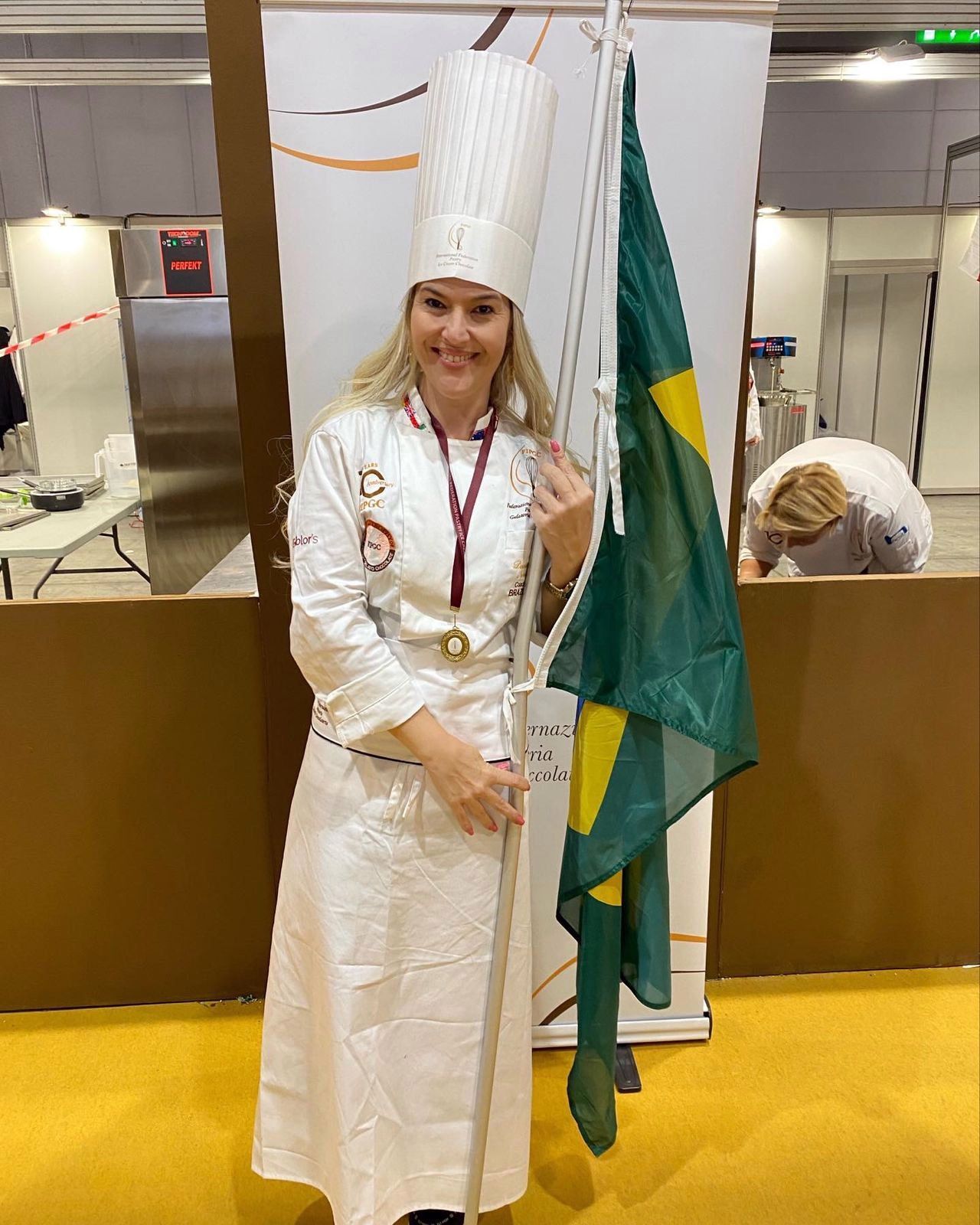 Uma mulher com chapéu de chef está segurando uma bandeira