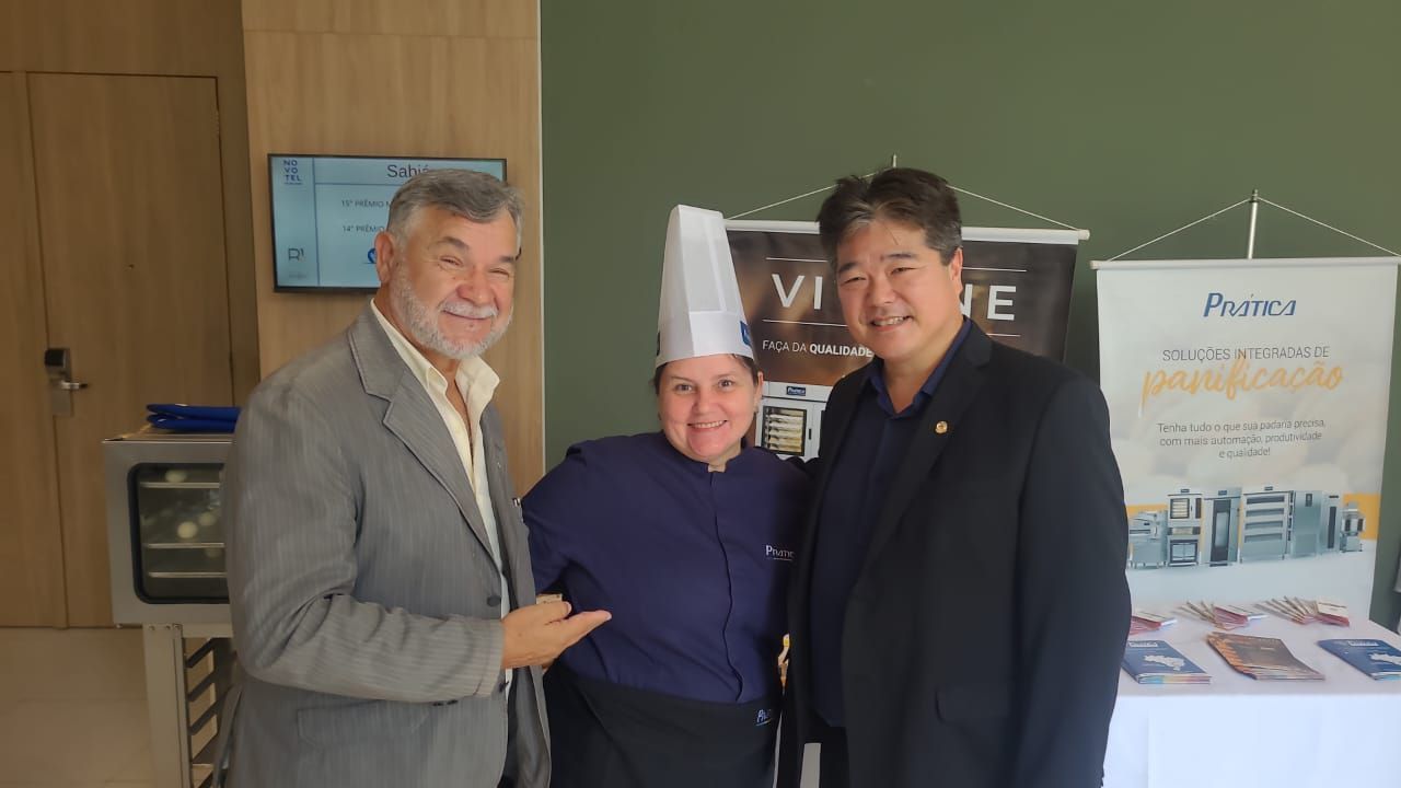 Um homem de terno e uma mulher com chapéu de chef estão posando para uma foto.