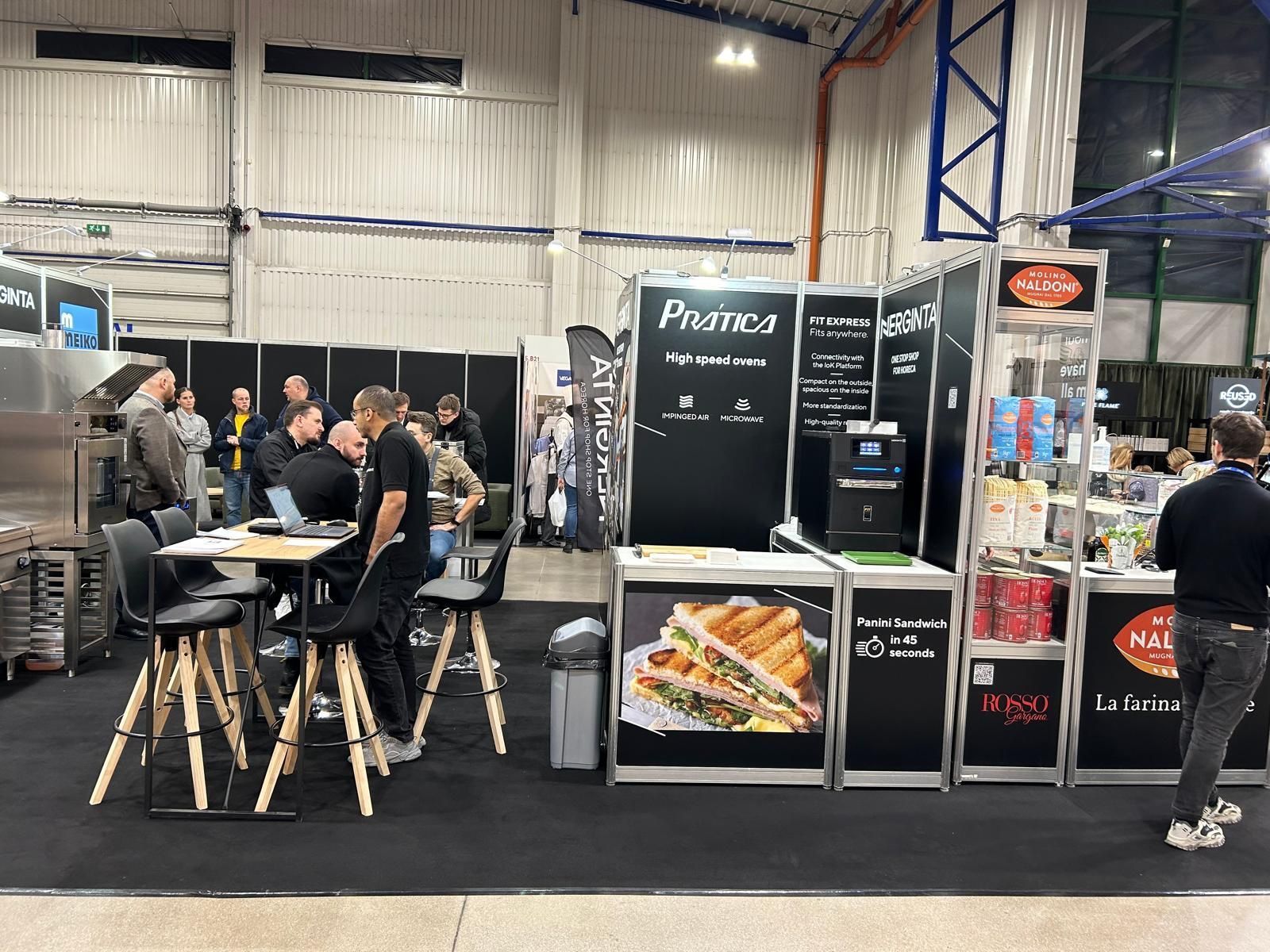 Um grupo de pessoas está sentado em mesas em uma sala.