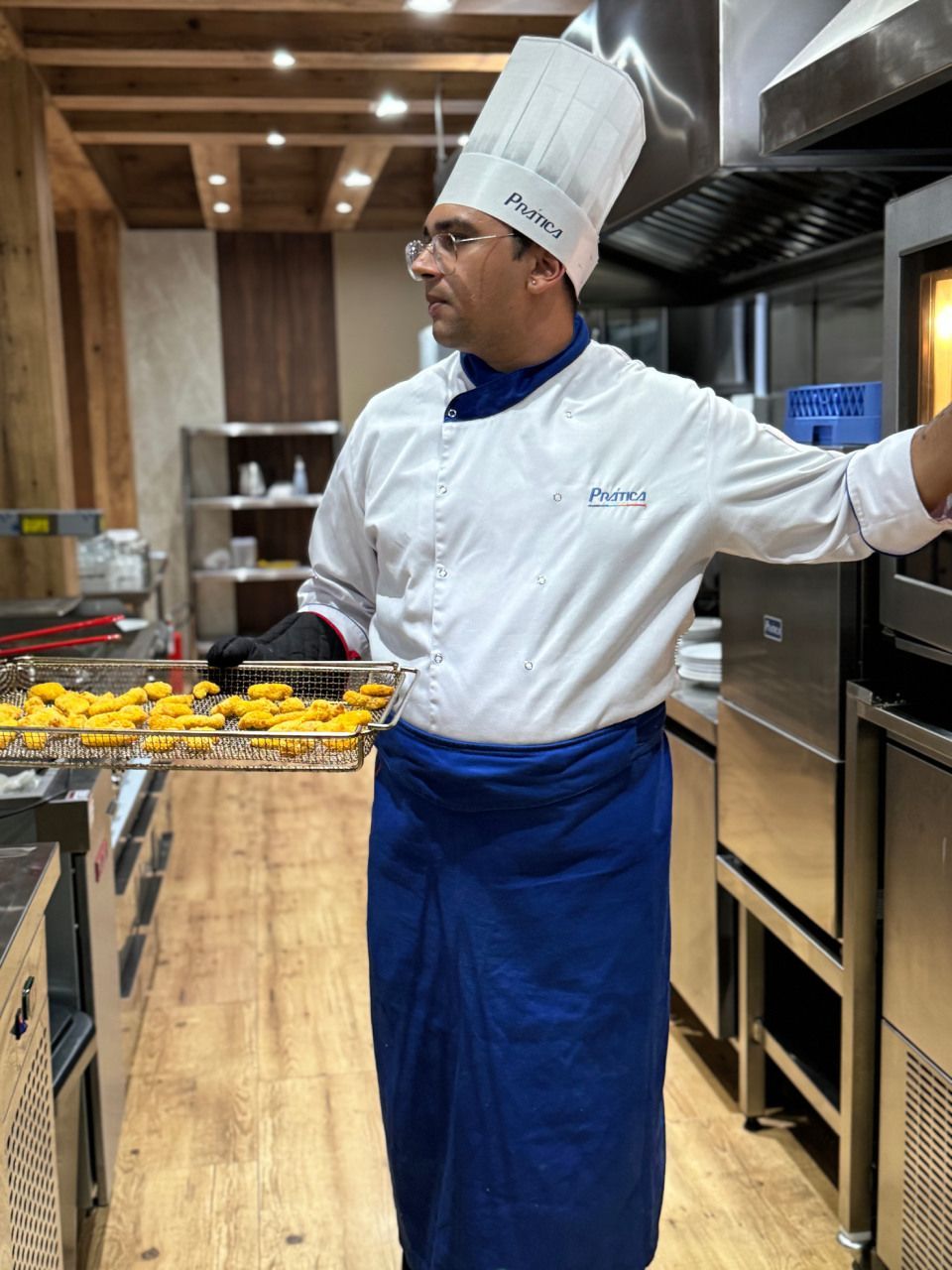 Um chef está segurando uma bandeja de comida em uma cozinha