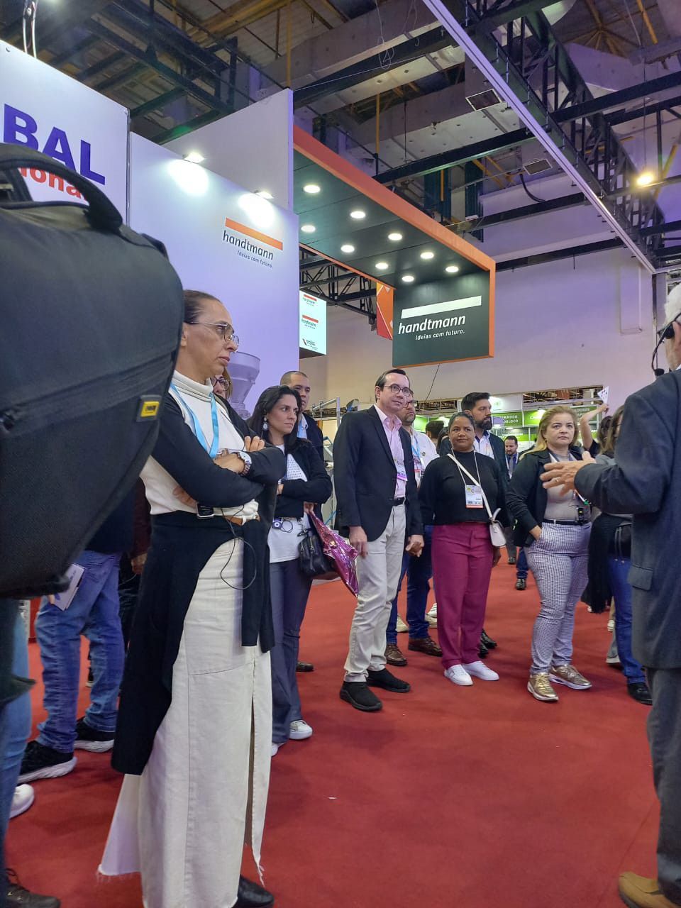 Um grupo de pessoas em frente a uma placa que diz bal