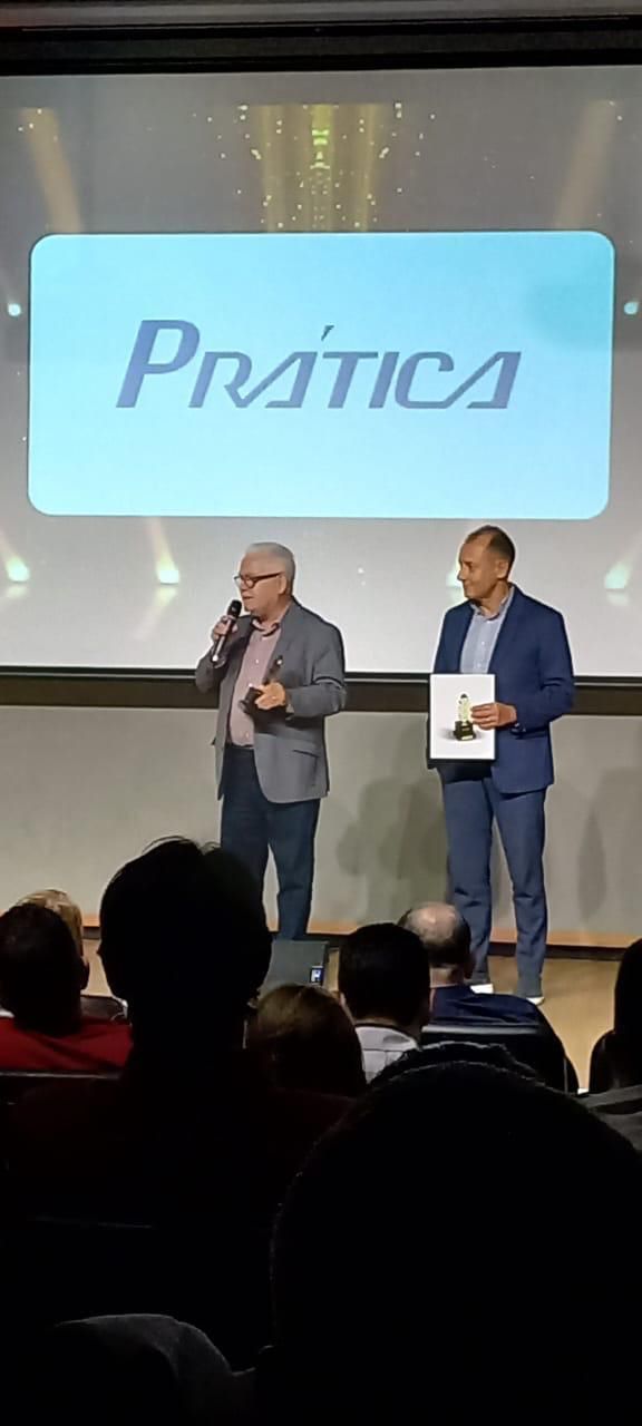 Dois homens estão em frente a uma tela de projetor fazendo uma apresentação.