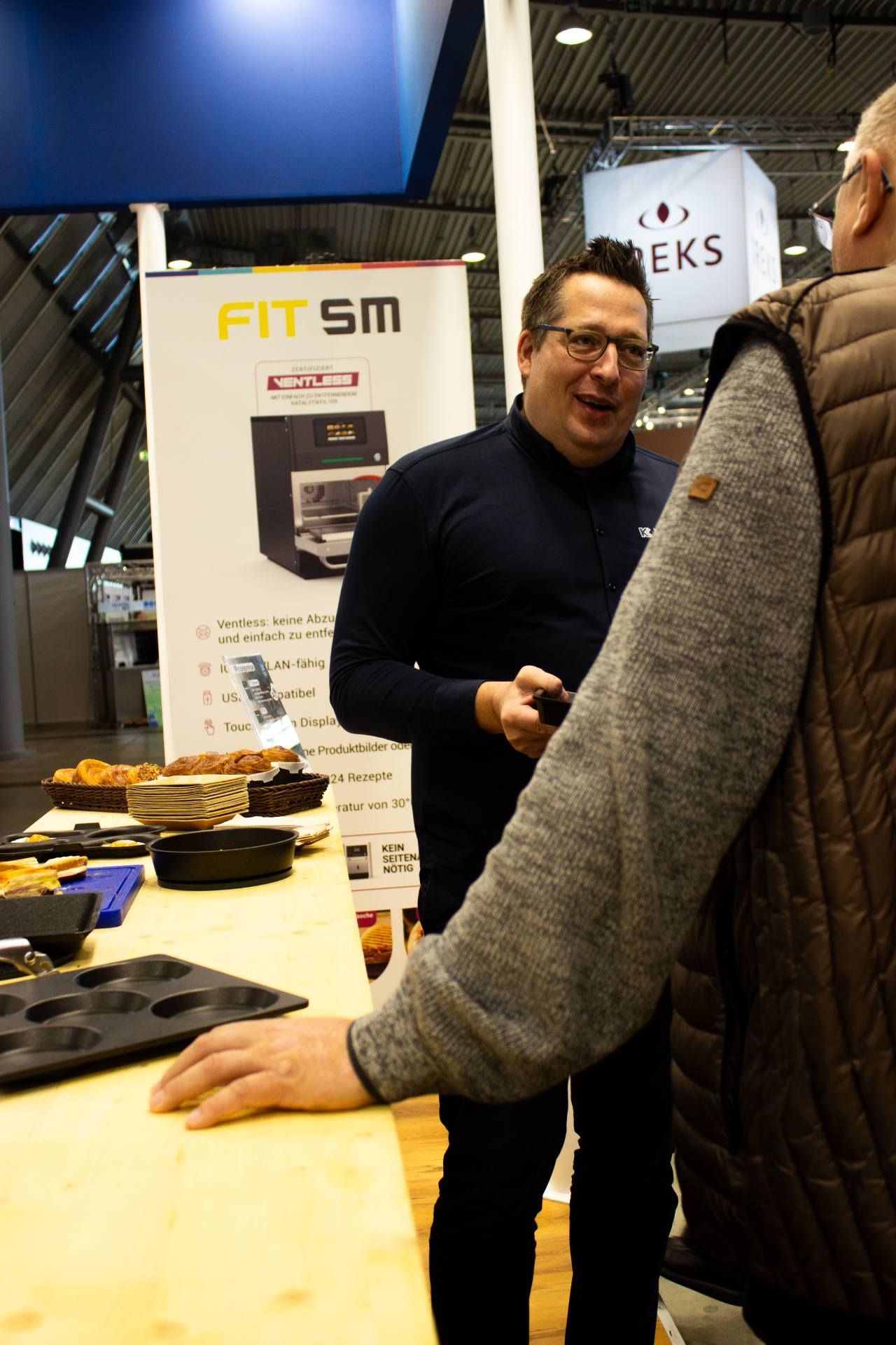 Um homem está parado em frente a uma placa que diz fit sm