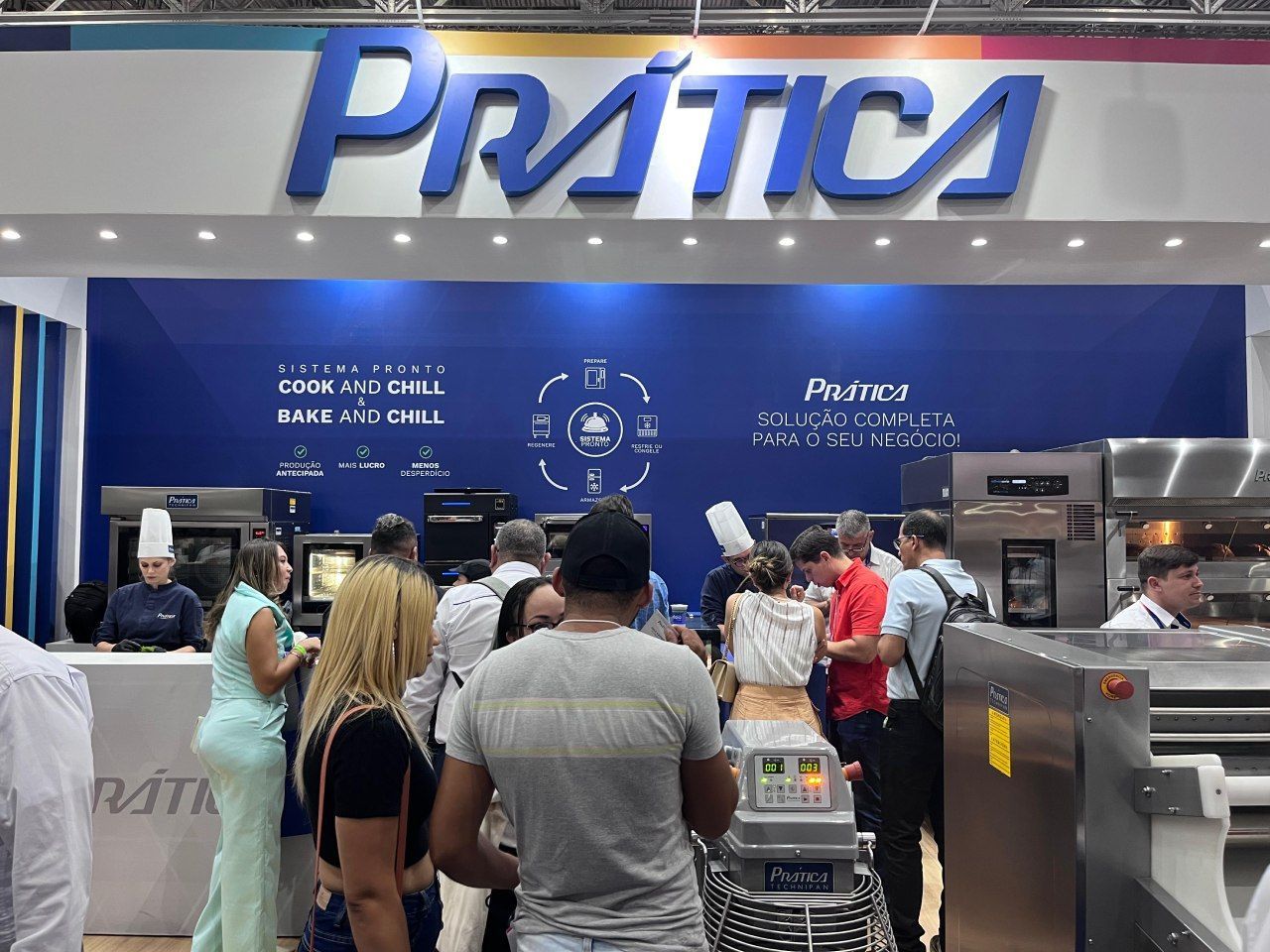 Um grupo de pessoas está em pé na frente de uma placa de prática