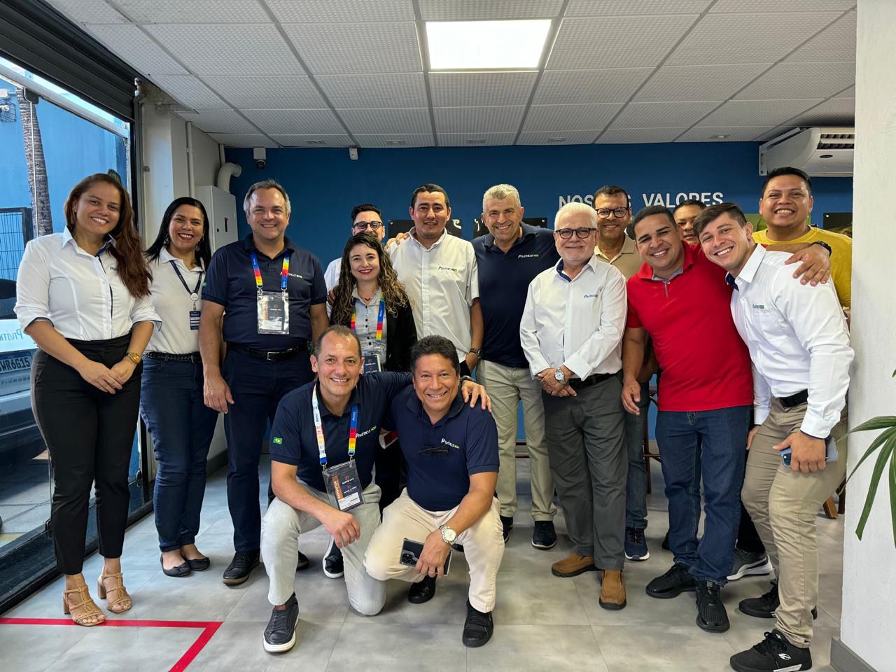 Um grupo de pessoas está posando para uma foto em uma sala.