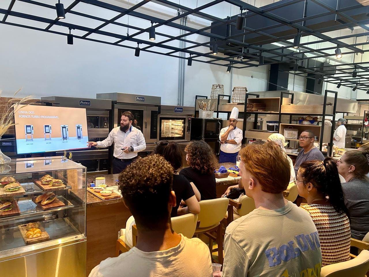 Um grupo de pessoas está sentado em um restaurante assistindo a uma apresentação.