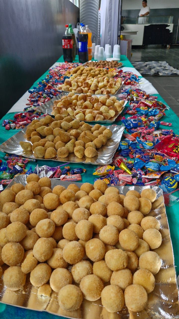 Uma mesa longa coberta com pratos de comida e doces.