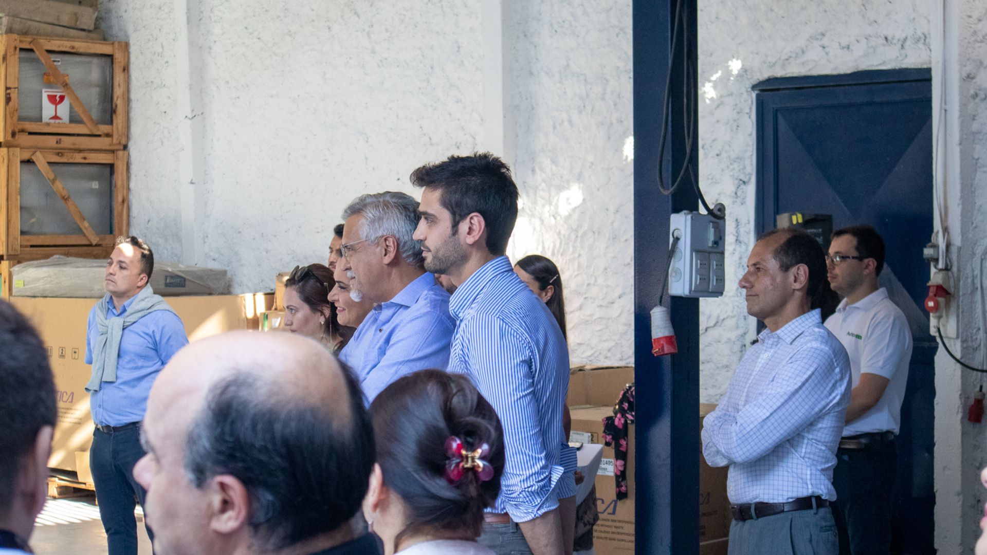 Um grupo de pessoas está em um armazém olhando para algo