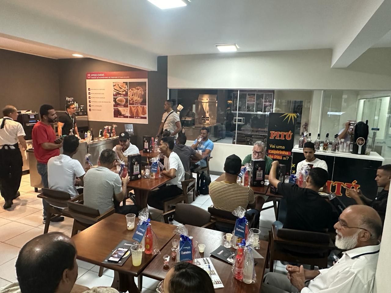 Um grupo de pessoas está sentado em mesas em um restaurante.