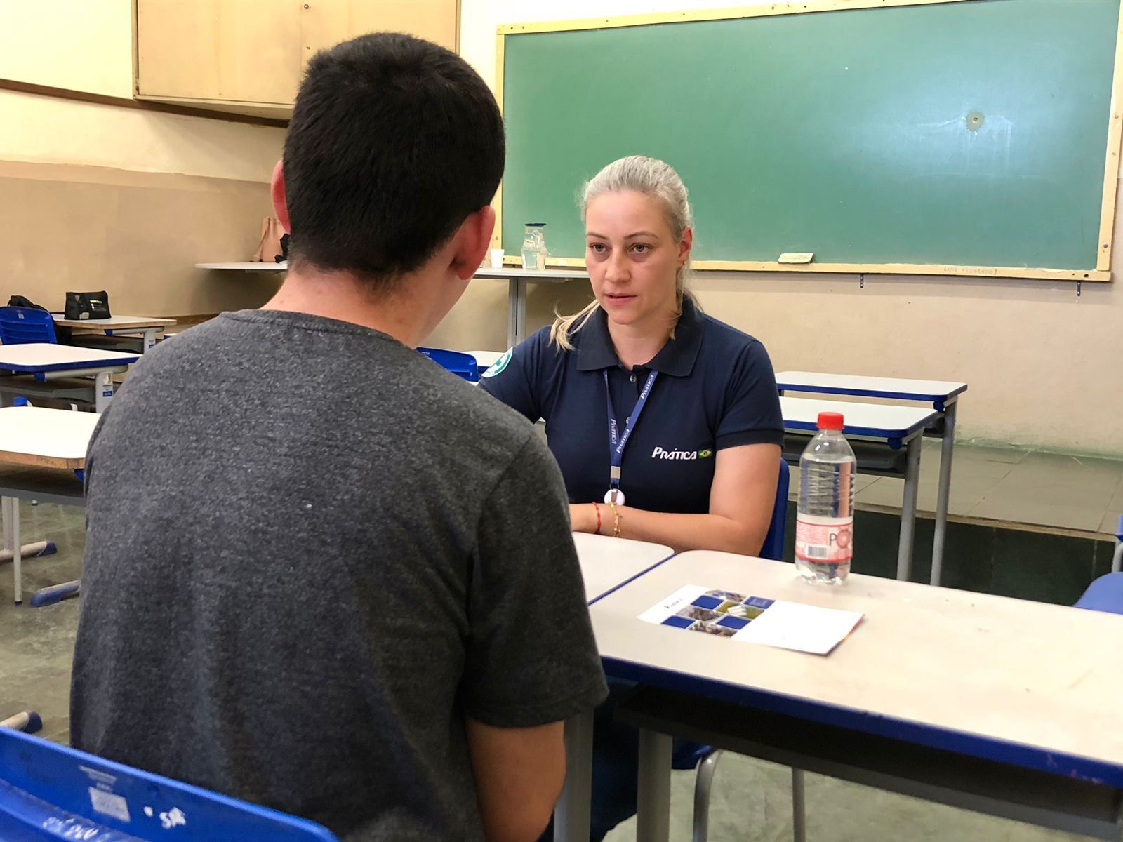 Uma mulher está conversando com um homem em uma sala de aula