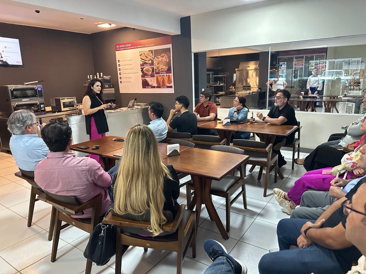 Um grupo de pessoas está sentado em mesas em um restaurante.